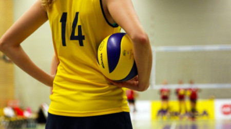 Rücken einer Volleyballspielerin im gelben Trikot