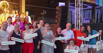 Menschengruppe mit Schildern in den Händen, auf denen "Neulandgewinner." steht