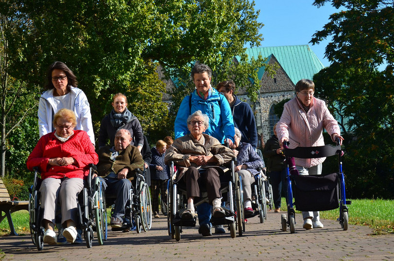 Freiwillige machen einen Spaziergang mit älteren Menschen aus dem SeniorenCentrum Elbblick