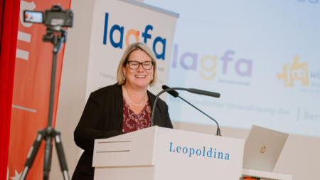 Staatssekretärin und Integrationsbeauftragte Susi Möbbeck Integrationsbeauftragte Susi Möbbeck während ihrer Rede auf der Landeskonferenz; sie steht an einem Rednerpult, hinter ihr ist das Logo der lagfa zu sehen.