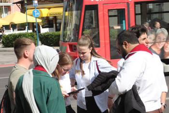 Gruppe junger Menschen, die auf der Straße stehen und auf ein Tablett schauen