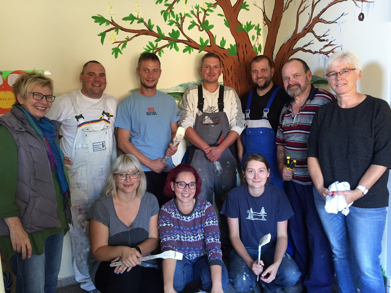 Gruppenbild der neun Freiwilligen, die beim Malern und Putzen der Kita geholfen haben.