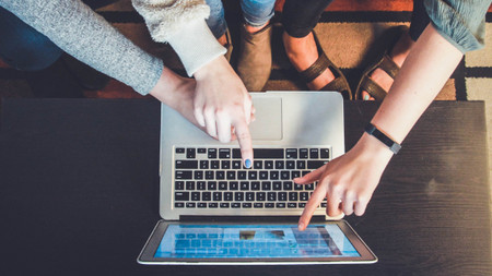 Drei junge Menschen vor einem Laptop